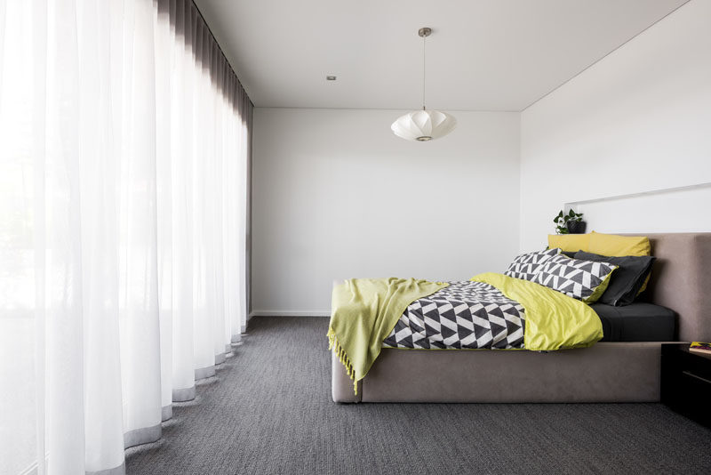 Simple furnishings have been used in this modern bedroom, and soft white curtains provide privacy without sacrificing the natural light. #ModernBedroom