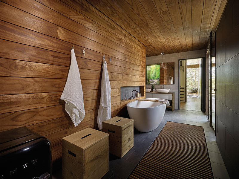 In this modern house, a walk-in dressing room is located between the master bedroom and the bathroom, while a door off the bathroom leads to a small private terrace. #Bathroom #Wood #ModernBathroom