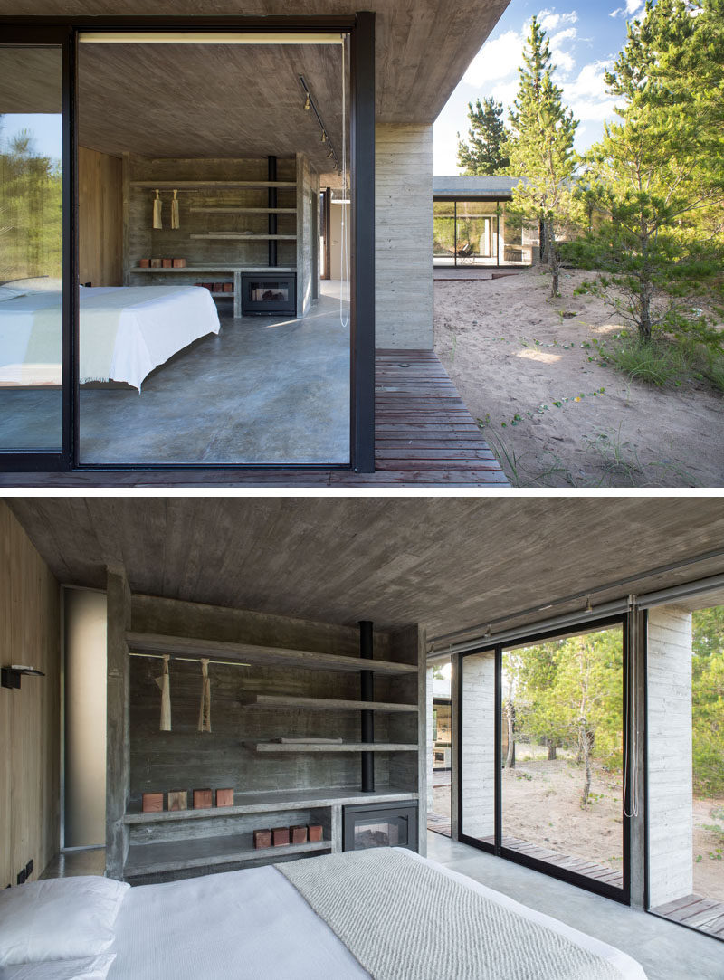 This modern master bedroom features a wood accent wall, an open wardrobe and sliding doors that open to a deck. #ExposedCloset #Concrete #Bedroom