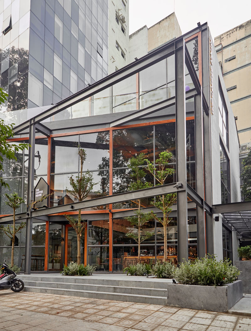 This modern coffee shop in Vietnam has double height windows, a garden and multiple seating areas. #ModernCoffeeShop #CoffeeHouse