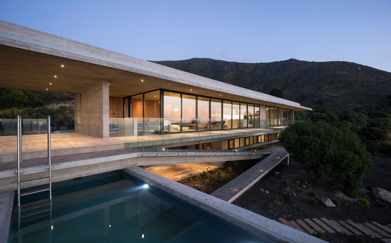 Felipe Assadi Arquitectos have designed House H, a modern concrete house that's located within the hills of Zapallar, Chile, and features a cantilevered swimming pool. Click through to see more photos of this house. #ConcreteHouse #Architecture #SwimmingPool