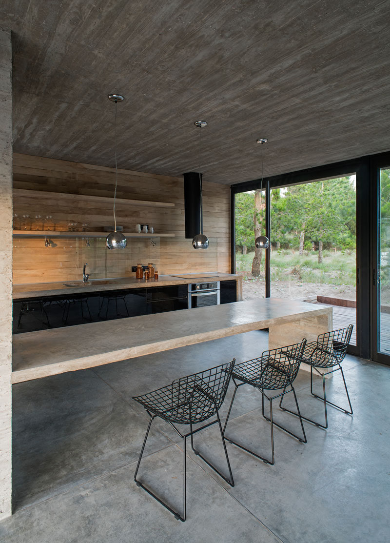 Smooth concrete was combined with high-gloss black cabinets for a modern and simple kitchen. #ConcreteKitchen #BlackCabinets #ConcreteCounters