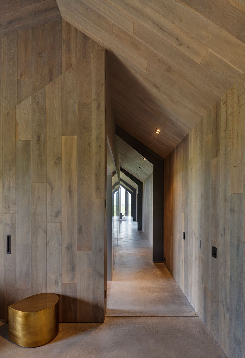 In this modern guest house, the hallway and ceiling is lined in wood, while the flooring is concrete. Click through to see more photos of the guest house. #Hallway #Wood #ConcreteFloor #InteriorDesign