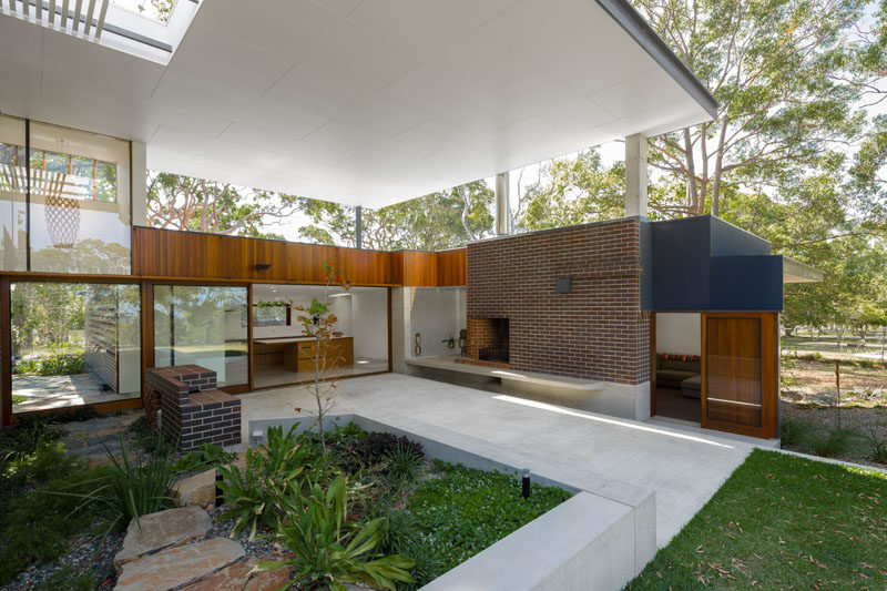 This covered outdoor space provides plenty of room for alfresco dining and relaxing in the shade. Click through to see more photos of this modern house. #OutdoorSpace #Landscaping