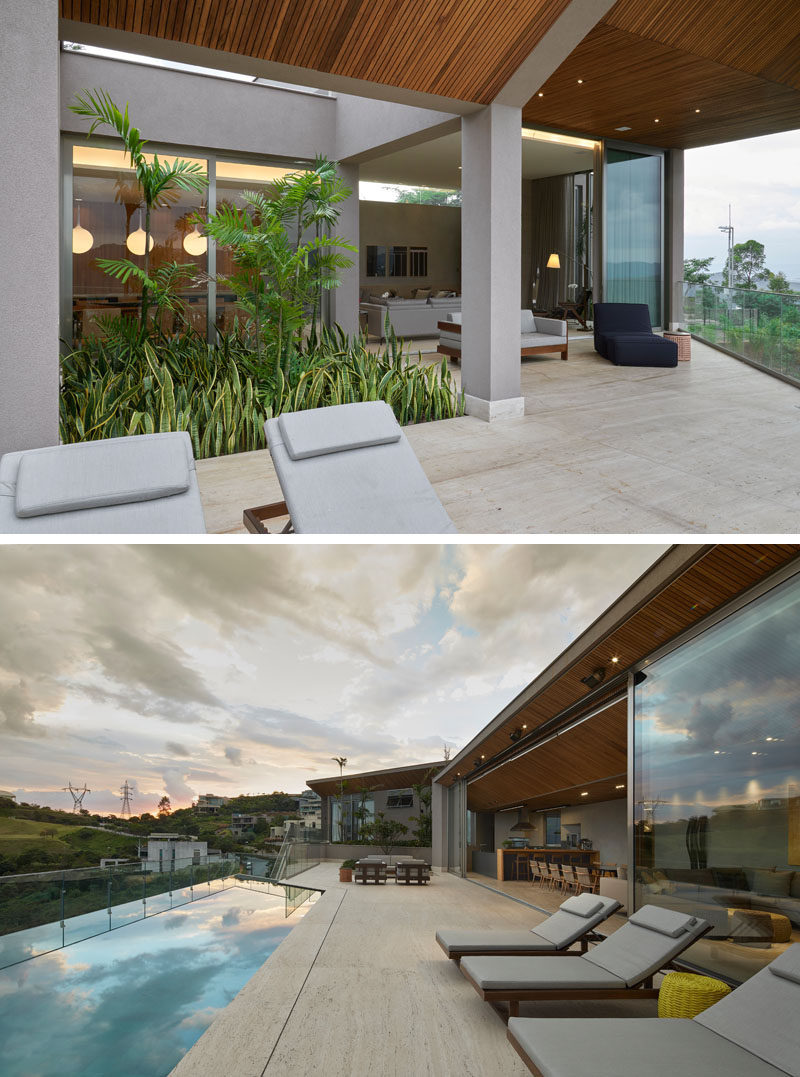 The living spaces of this modern house open up to an outdoor space with a variety of seating options and a swimming pool that looks out over the valley below. #SwimmingPool #Deck #ModernHouse