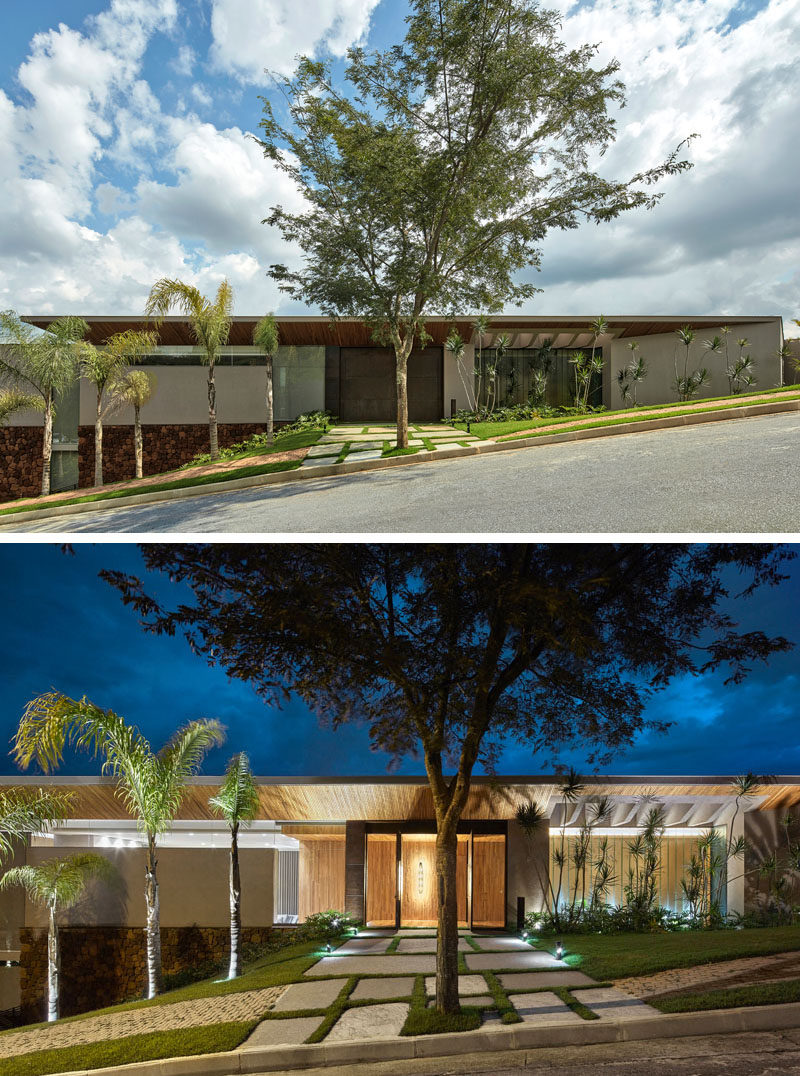 A landscaped garden and path leads to the large steel front door of this modern house. #Landscaping #FrontDoor