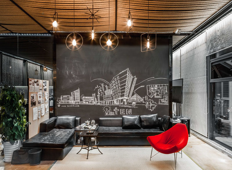 In this meeting room, rope has been used to cover the ceiling, while a chalkboard wall allows the space to be ever changing with the use of art. Click through to see more photos of this modern workplace. #ModernOffice #ModernWorkplace #MeetingArea #RopeCeiling #ChalkboardWall