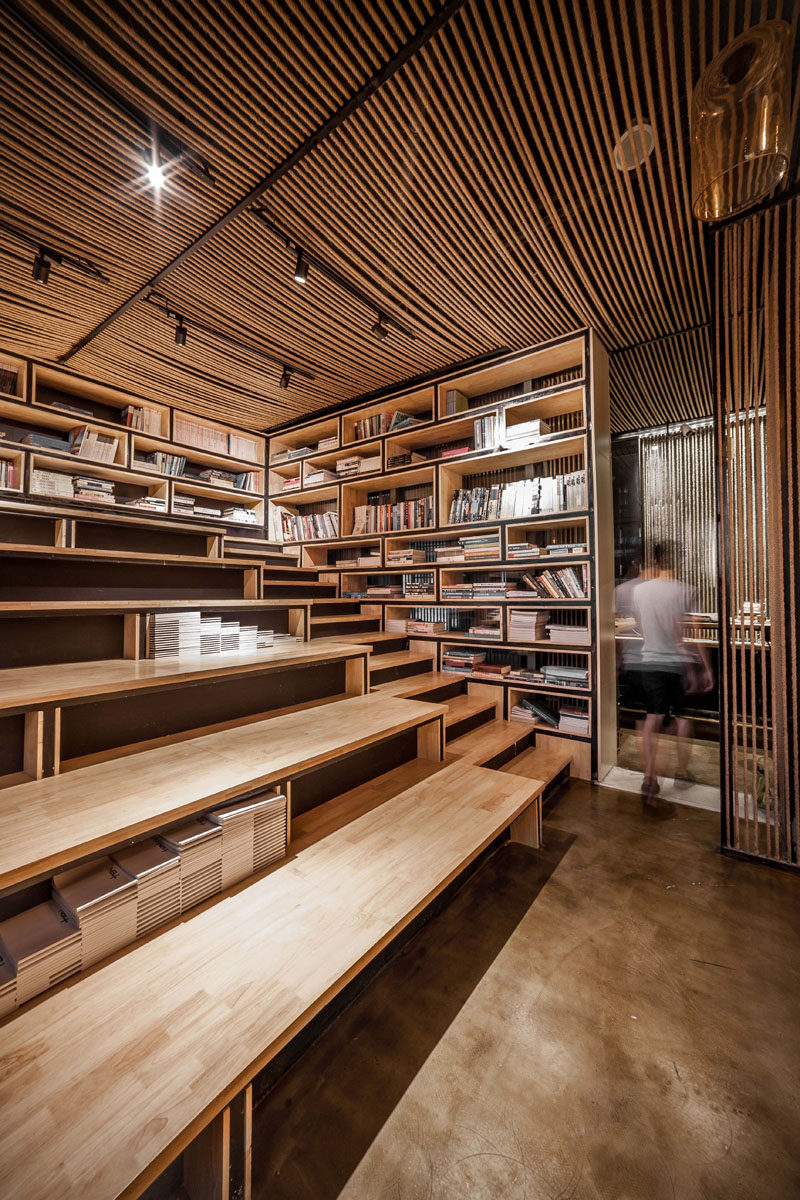 This modern office has rope ceilings and partitions, as well as a library with open shelving and tiered seating. Click through to see more photos of this modern office. #Library #ReadingArea #OfficeDesign #Workplace #TieredSeating #Bookshelves