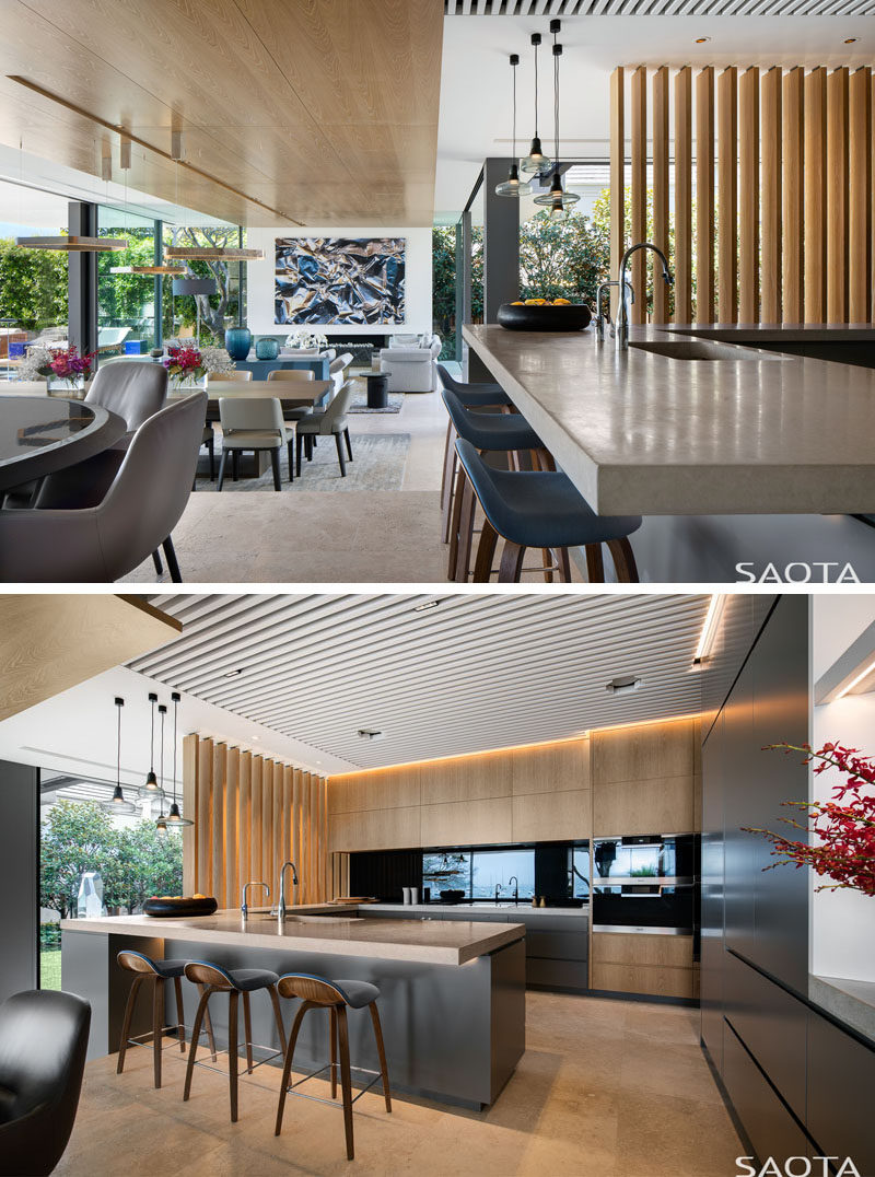 The main social areas of this modern house are all open plan, with stairs, rather than walls, helping to define the various areas. #ModernInterior #OpenPlan #BlackAndWoodKitchen