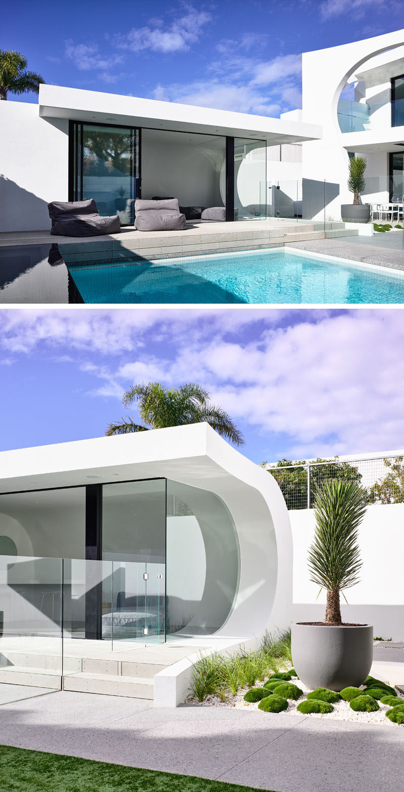 This modern backyard has an infinity edge spa and pool, and a wave style pool house. Click through to see more photos of this modern house. #Pool #SwimmingPool #PoolHouse #Architecture #Cabana