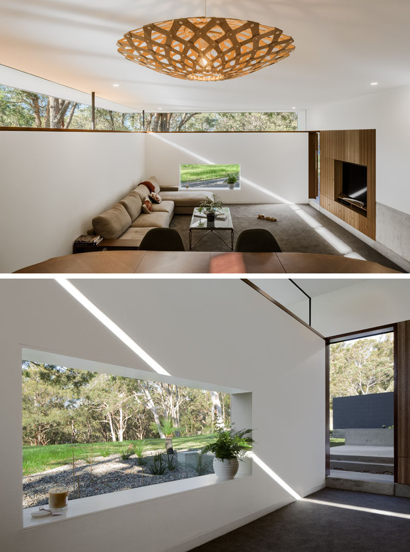 This modern house has a sunken living room with windows that allow for natural light and views of the surrounding nature. Click through to see more photos of this modern house. #SunkenLivingRoom #Windows #LivingRoom