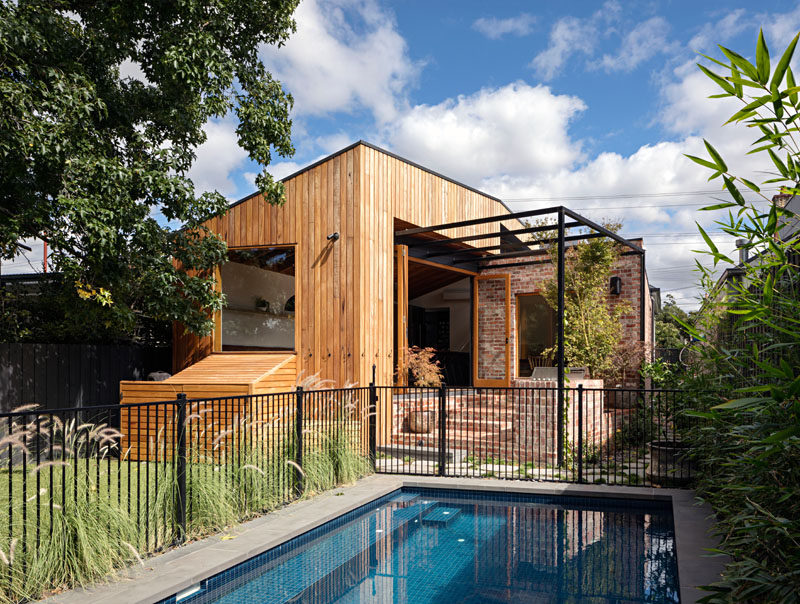 This modern house addition features a wood and brick exterior with a sloped roof. Click through to see more photos. #HouseExtension #HouseAddition #Architecture