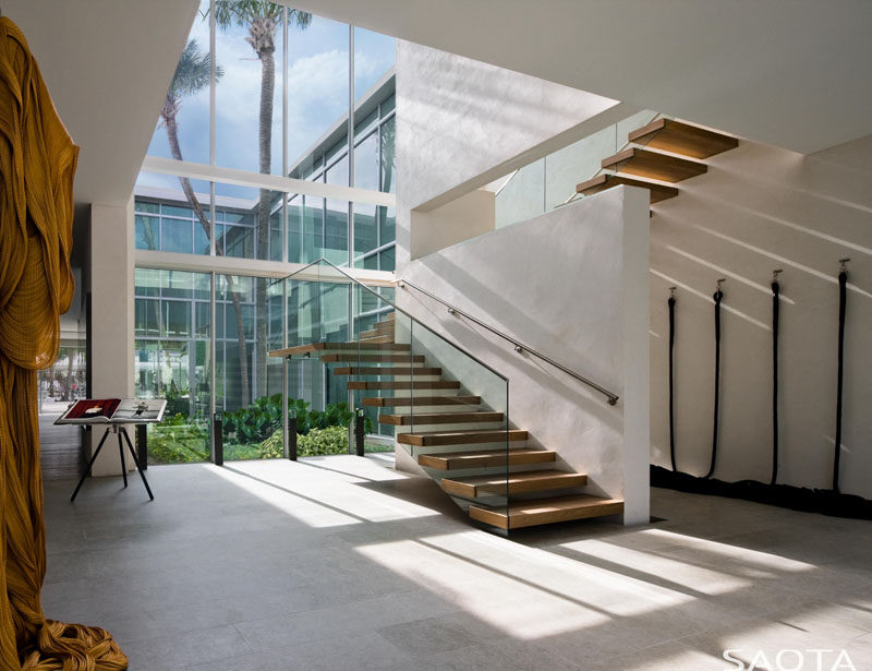 A wall of windows floods the wood and glass stairs with natural light. #Stairs #Windows