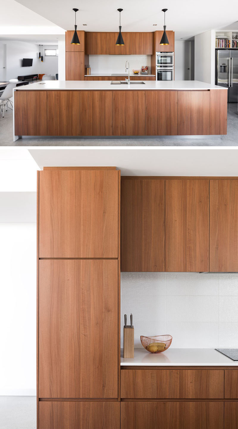 In this kitchen, wood has been used for the cabinetry, while the white countertops and backsplash help to keep it bright and complete the modern look. #ModernKitchen #WoodKitchen #WhiteCounters