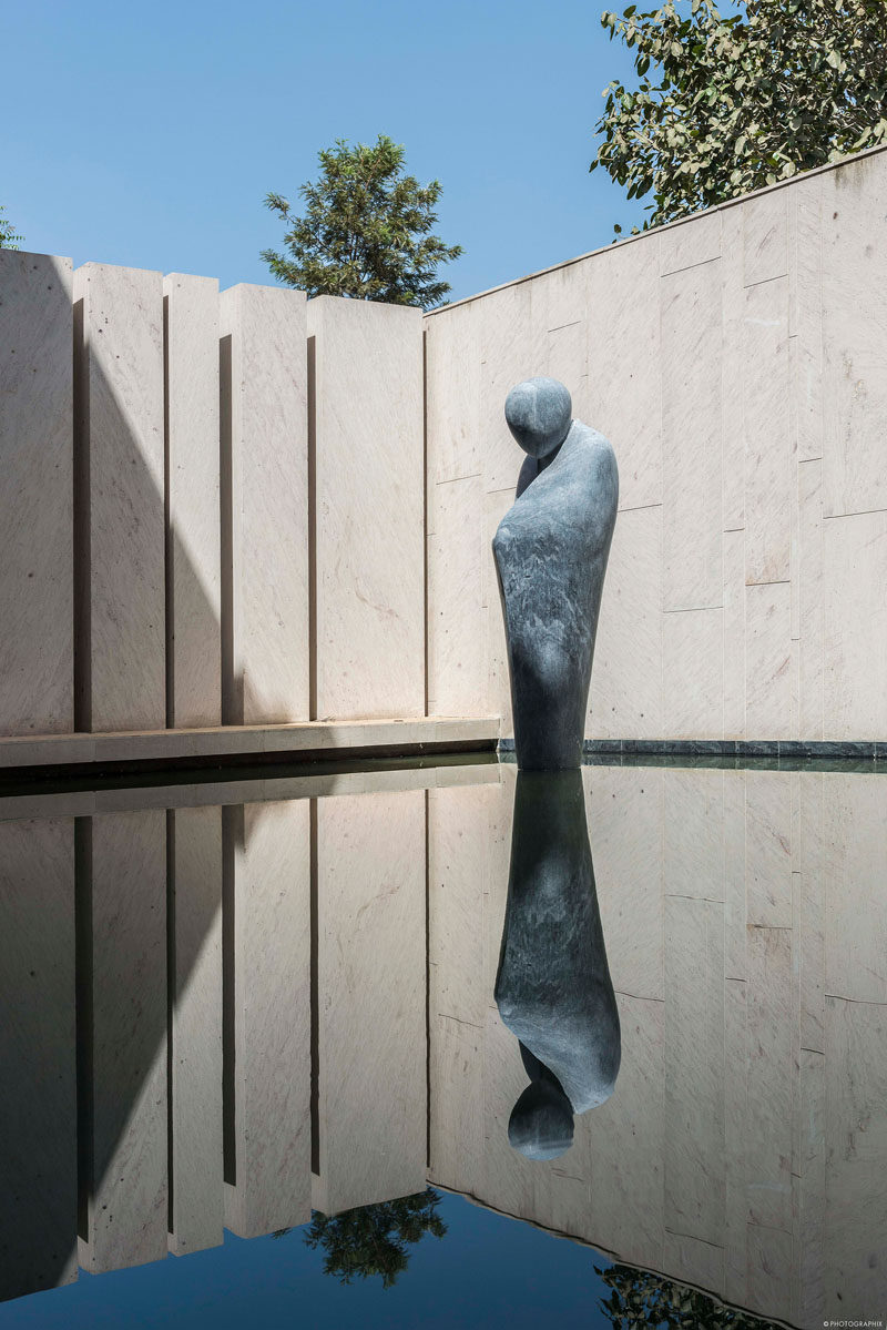 This modern water feature has a life size sculpture of a pensive monk, made from Beslana stone, that's gingerly poised on the water’s surface as if levitating. #WaterFeature #Sculpture #Landscaping