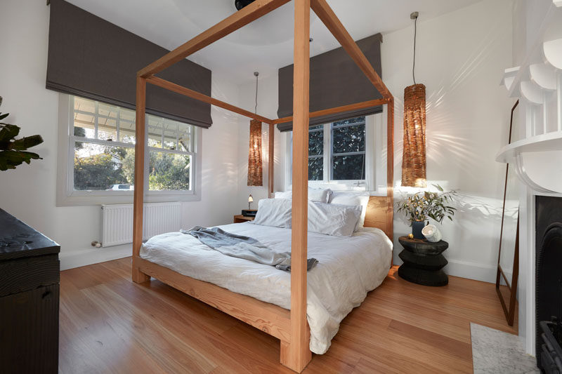 A simple four post wooden bed frame matches the wood flooring in this contemporary bedroom. #BedroomDesign #InteriorDesign