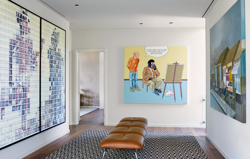 A hallway that connects the bedrooms in this modern house is lined with the home owners art collection. #ModernHallway #Gallery #InteriorDesign