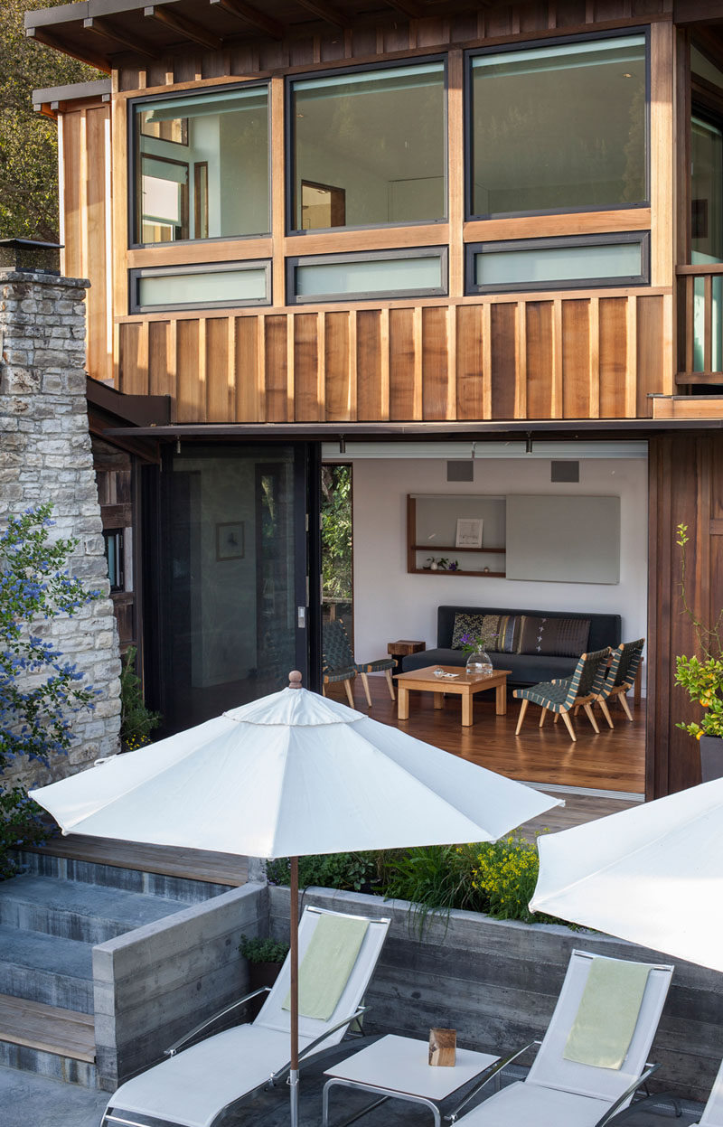 An addition with board and batten siding was added to a small cottage with a stone fireplace. #Addition #Cottage #Architecture