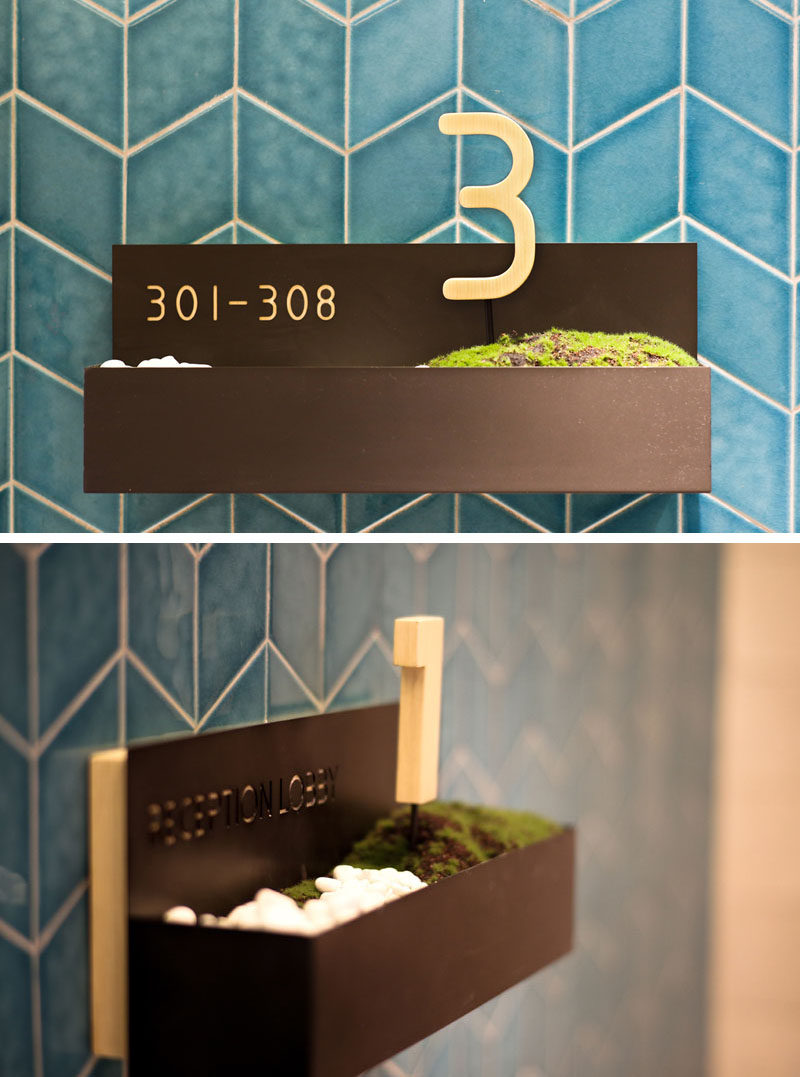 This modern hotel in Hong Kong includes room signage that features pebbles and moss in a small wall-mounted planter. #HotelDesign #InteriorDesign