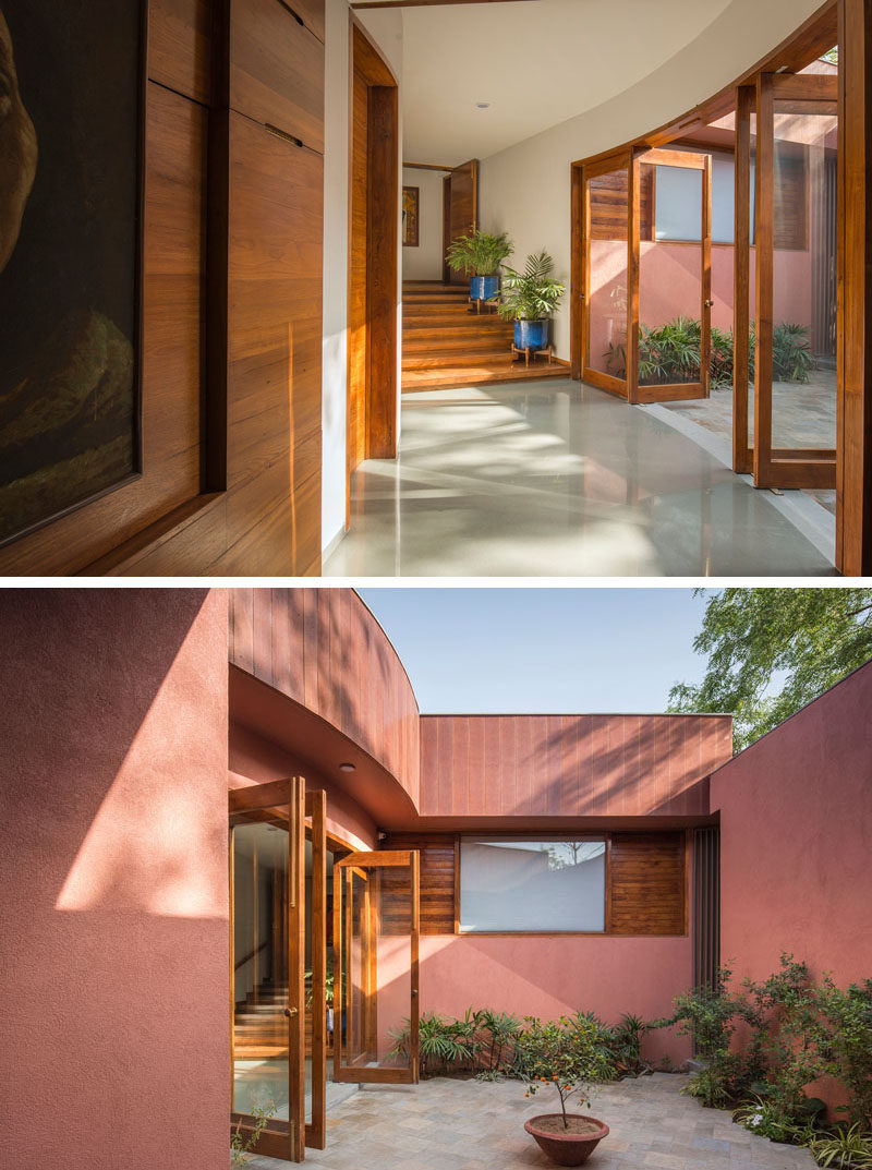 Located just off a curved hallway in this contemporary house, is a small private courtyard with a patio and plants. #Courtyard #Hallway #Doors