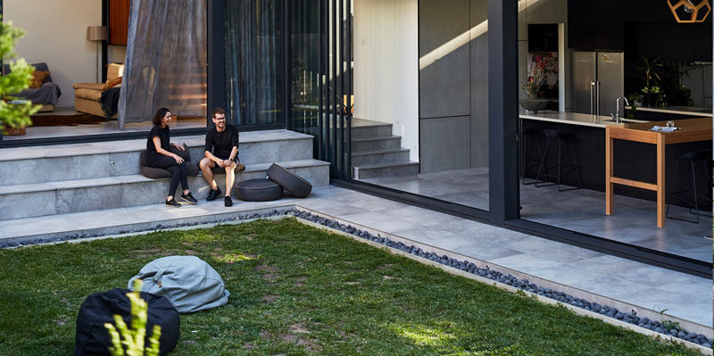 This modern landscaped backyard has steps that lead down to a grassy lawn. #Landscaping #Backyard #OutdoorSteps #Stairs