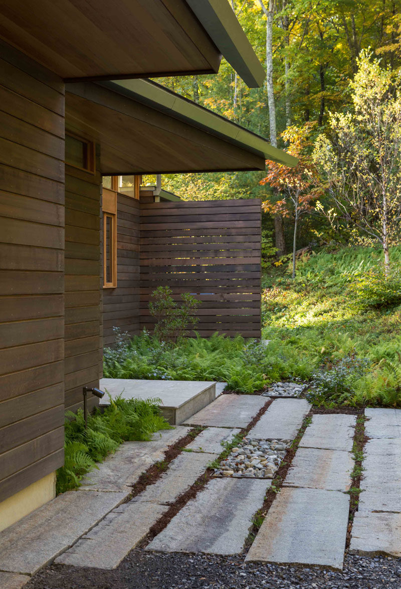 This modern house has an earthy palette with black stained cedar siding, mahogany windows and a natural zinc colored metal roof. #BlackCedarSiding #MahoganyWindows #MetalRoof #Landscaping