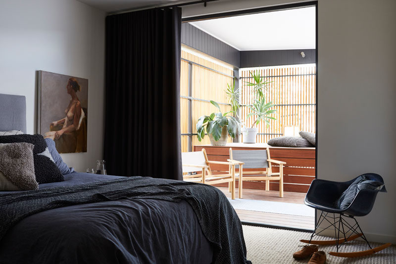 In this contemporary master bedroom, a sliding glass door opens to reveal a private patio. #BedroomDesign #Patio
