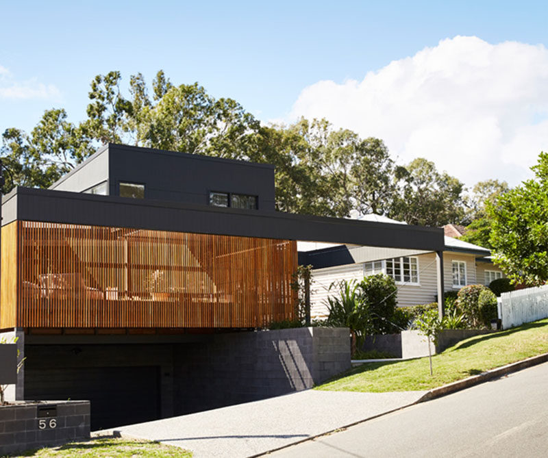 This modern black house has a wood slat detail that hides a private patio. #ModernHouse #ModernArchitecture