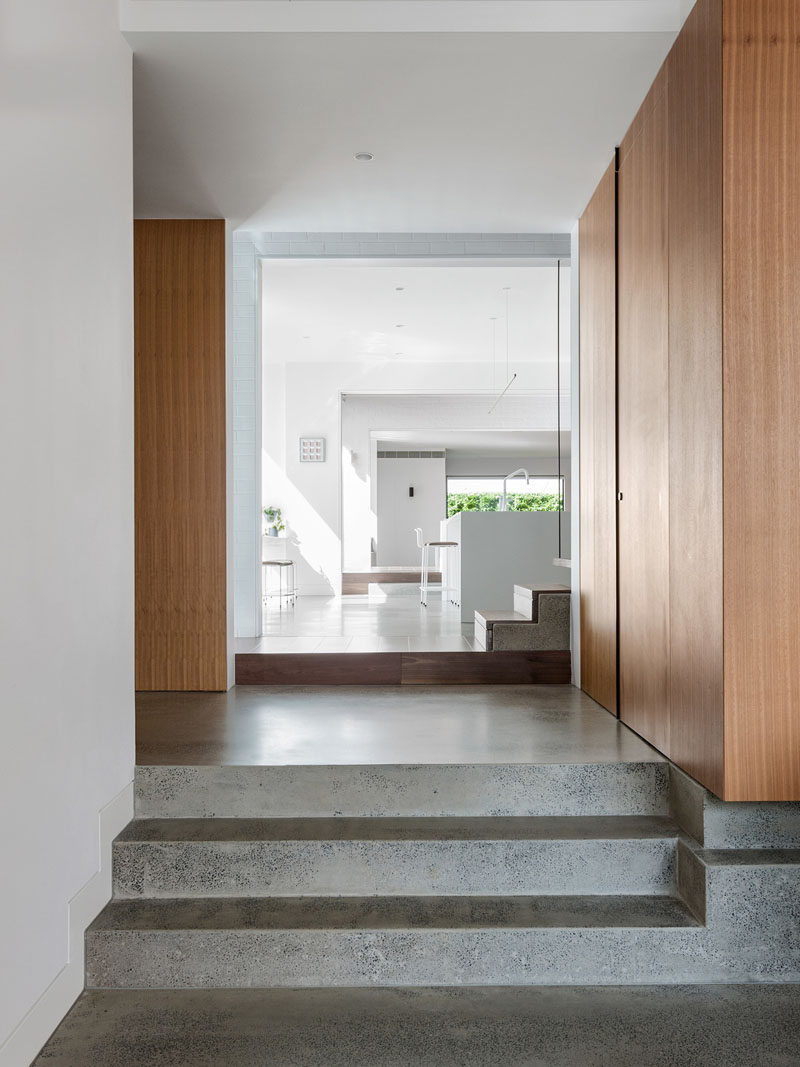 This modern house features polished concrete flooring, wood cabinetry and accents, and bright white walls. #ModernHouse #ConcreteFlooring #WhiteWalls #WoodCabinetry