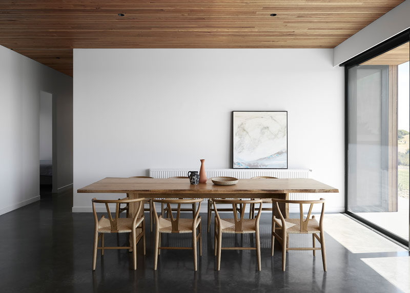 This dining room features a burnished concrete floor and a Blackbutt shiplap ceiling. #Shiplap #DiningRoom #ConcreteFloor