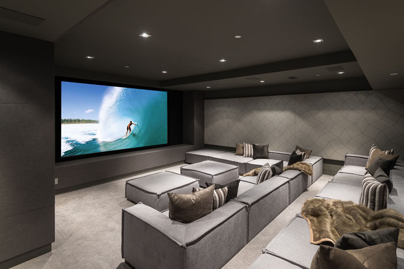 This modern house has a state-of-the-art home theater with comfortable stadium seating. #HomeTheater #MovieRoom #InteriorDesign