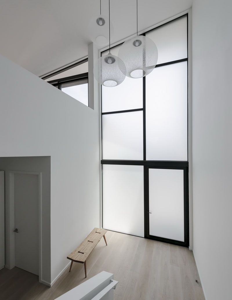 This house features tall frosted windows in the foyer that provide privacy from the street and still enable the natural light to travel inside. #Windows #FrostedGlass #Foyer #Entryway #Minimalist