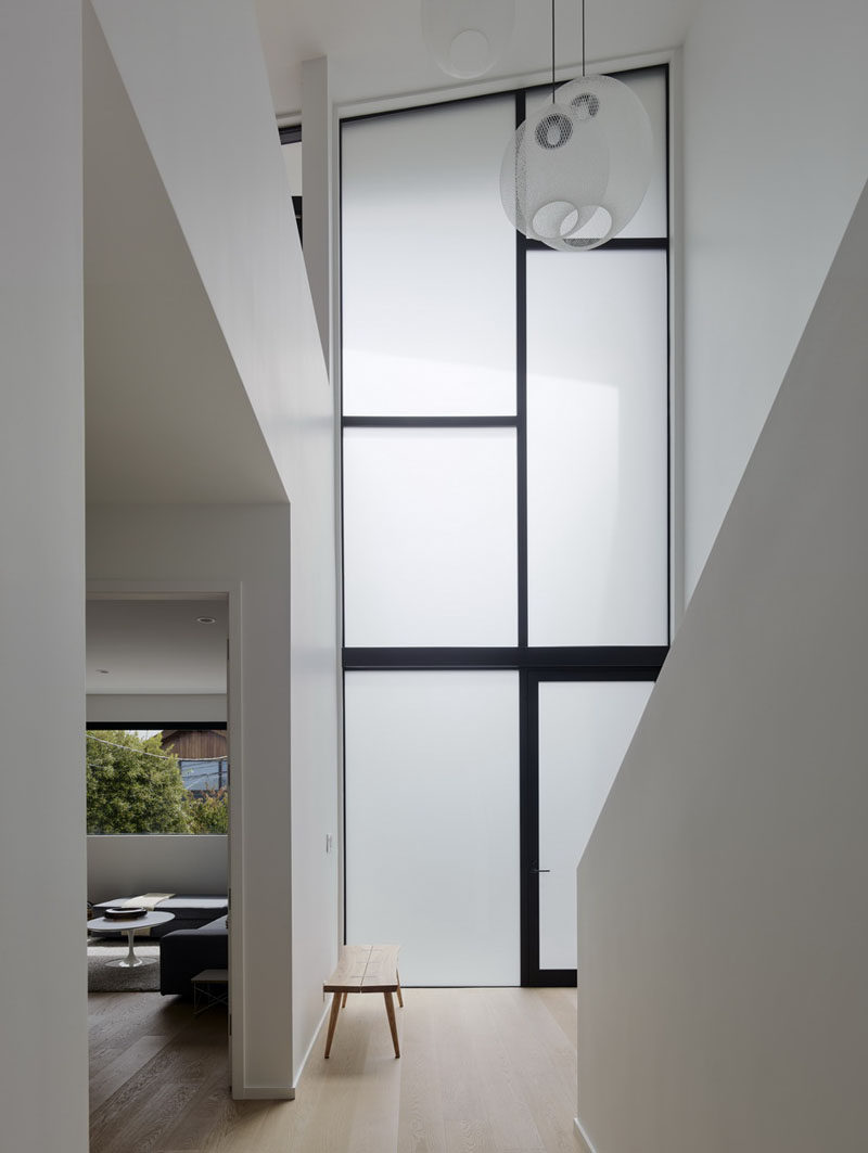 This house features tall frosted windows in the foyer that provide privacy from the street and still enable the natural light to travel inside. #Windows #FrostedGlass #Foyer #Entryway #Minimalist