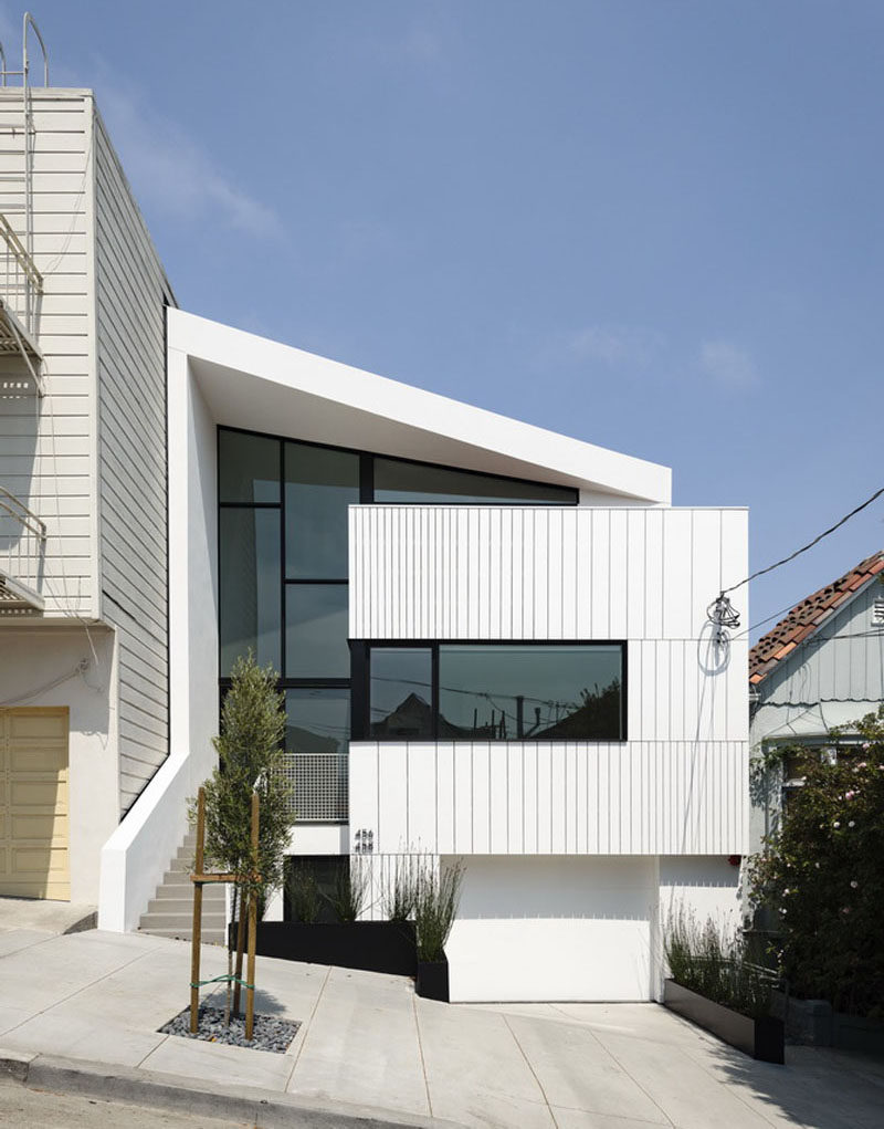 The facade of this modern house has been built from a rhythmic display of pre-manufactured trim boards. #ModernHouse #WhiteAndBlack #Architecture