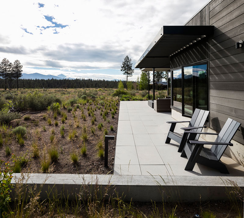 The modern patio of this house features a large format precast concrete pavers. #Patio #Landscaping #LandscapeDesign #HouseDesign