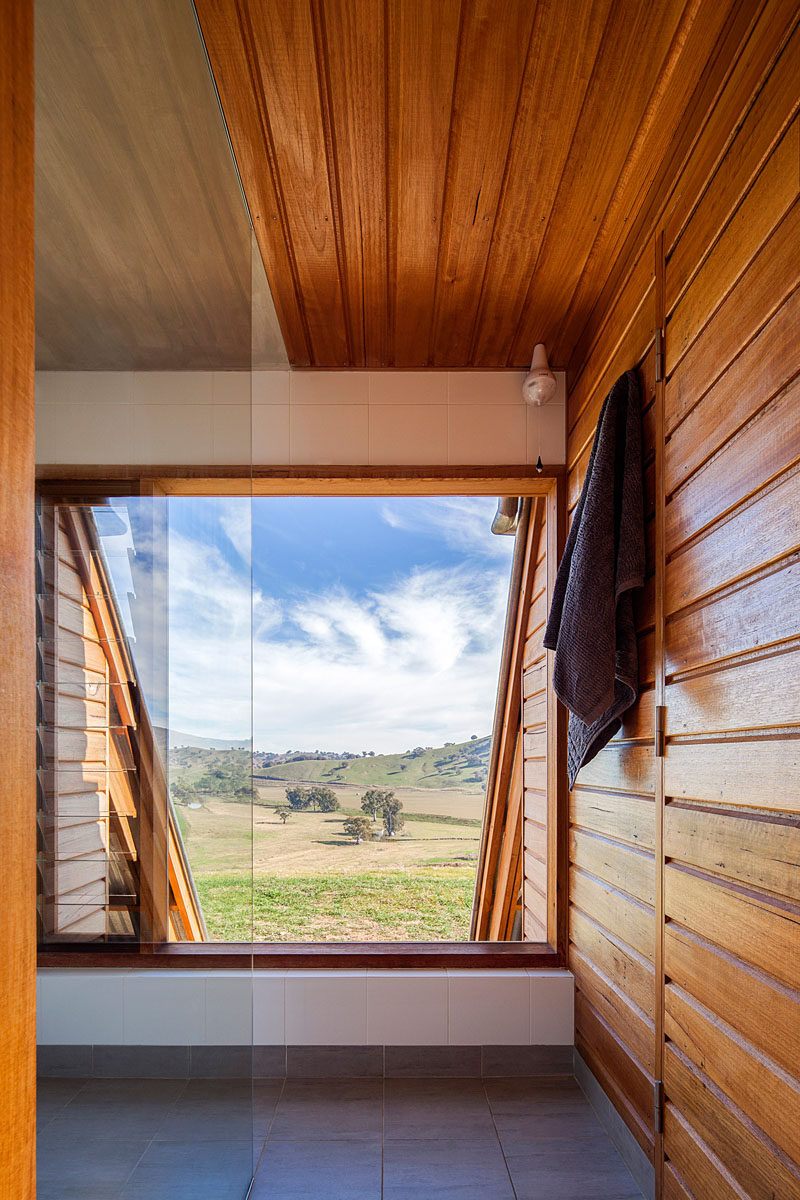 This large window in a bathroom provides views of the surrounding farmland. #Windows #Bathroom #WoodWalls