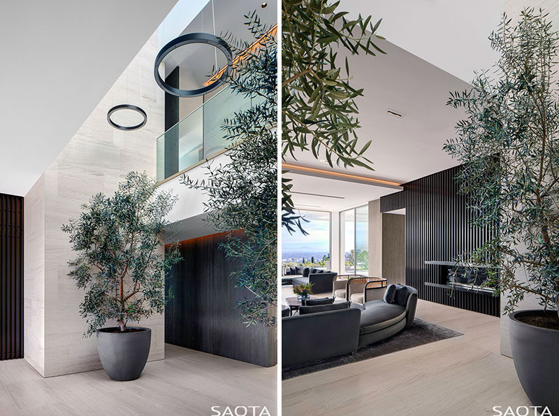 This modern entrance lobby features trees in pots and high ceilings. #Foyer #InteriorDesign #Plants #Lobby