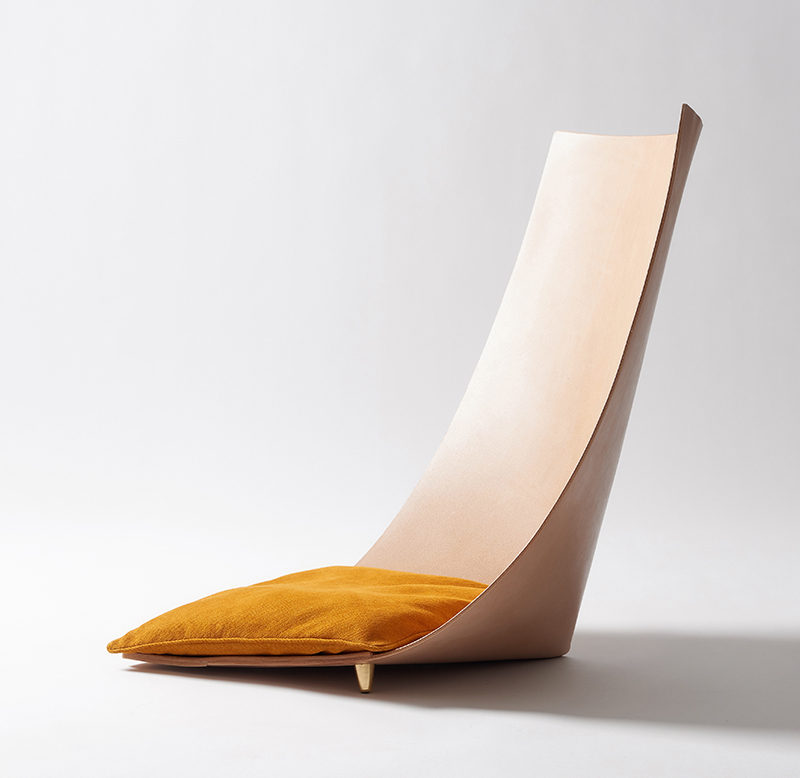 Jordi Ribaudí has designed a modern and sculptural chair, that's made from a single leather piece that backs back on itself to create the backrest, while small brass feet keep the structure together. #Design #Furniture #Chair #Seat #Leather