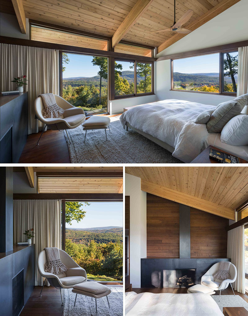 This modern master bedroom has large windows, a sloped wood ceiling and a fireplace. #MasterBedroom #Fireplace #Windows #WoodCeiling