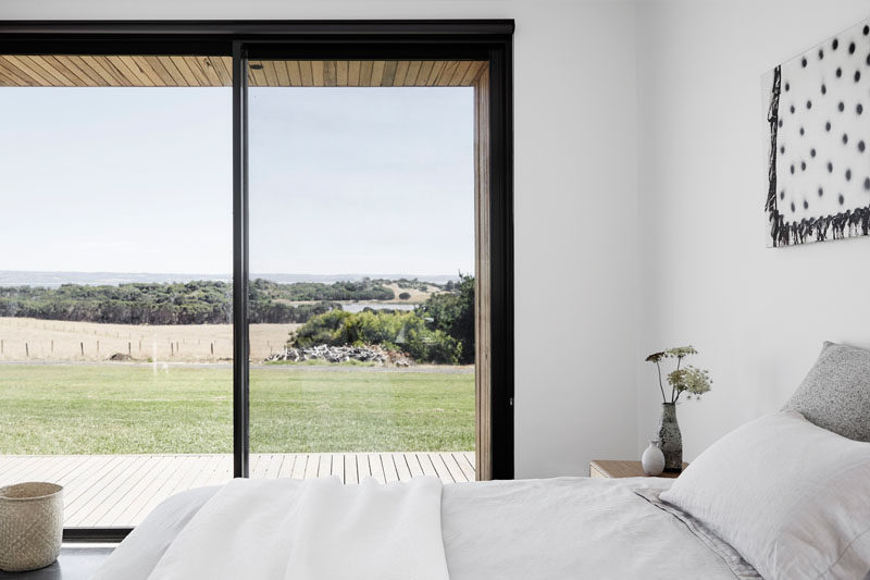 In this modern bedroom, the furnishings have been kept simple yet comfortable, and a sliding glass door opens to the deck. #ModernBedroom #BedroomDesign