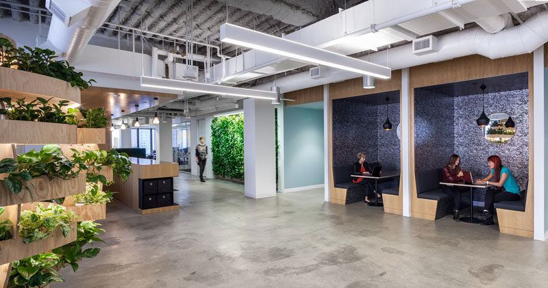 This modern office has open booths for small meetings, and nearby is a green wall and a Growroom that adds touches of nature to the environment. #Booths #Workplace #OfficeDesign #Greenwall