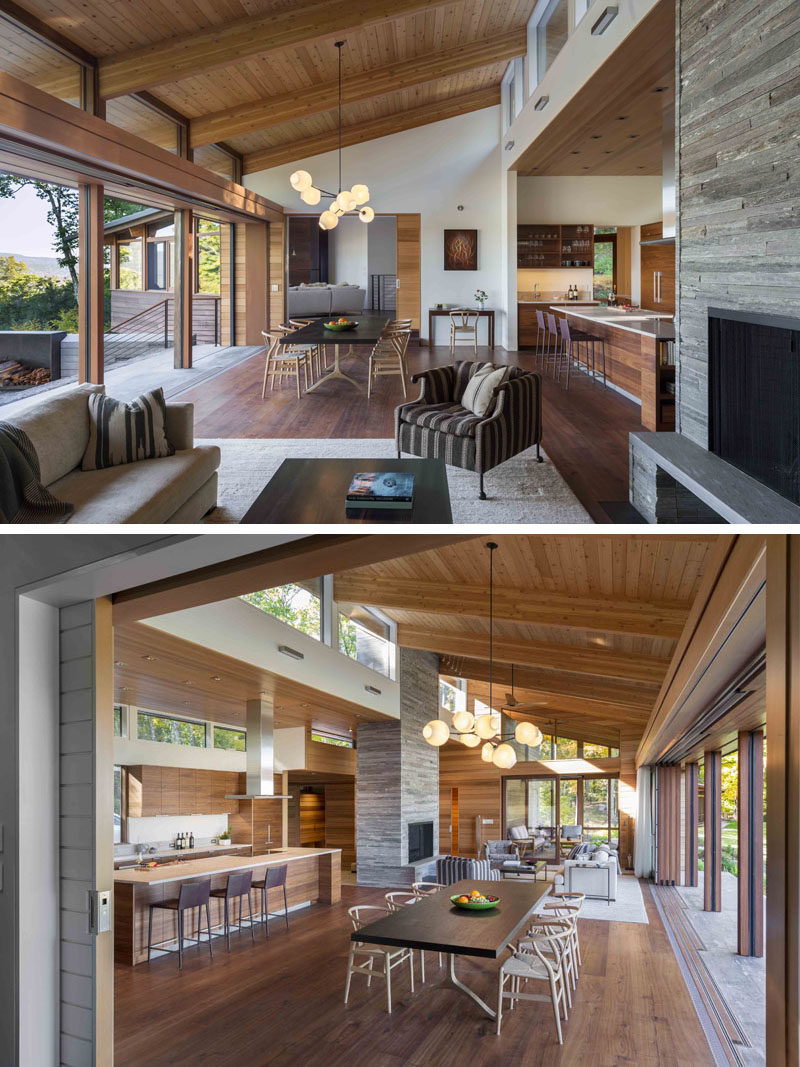 The dining room in this modern house, has a dark wood table and light wood chairs, and is anchored in the open floor plan by a chandelier. #DiningRoom #Chandelier #OpenPlanLiving