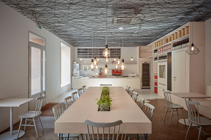 mars.s architects have designed a modern bistro with an irregular web semi-transparent suspended ceiling made from black string. #ModernBistro #ModernInterior #ModernRestaurant #InteriorDesign #Ceiling