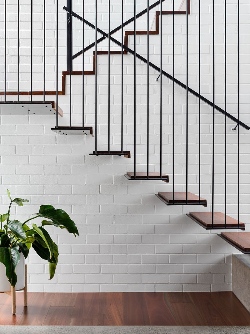 These stairs, which are minimalist in their design, transition from being open to being part of the white painted brick wall. #ModernStairs #MinimalistStairs #WhiteBrick