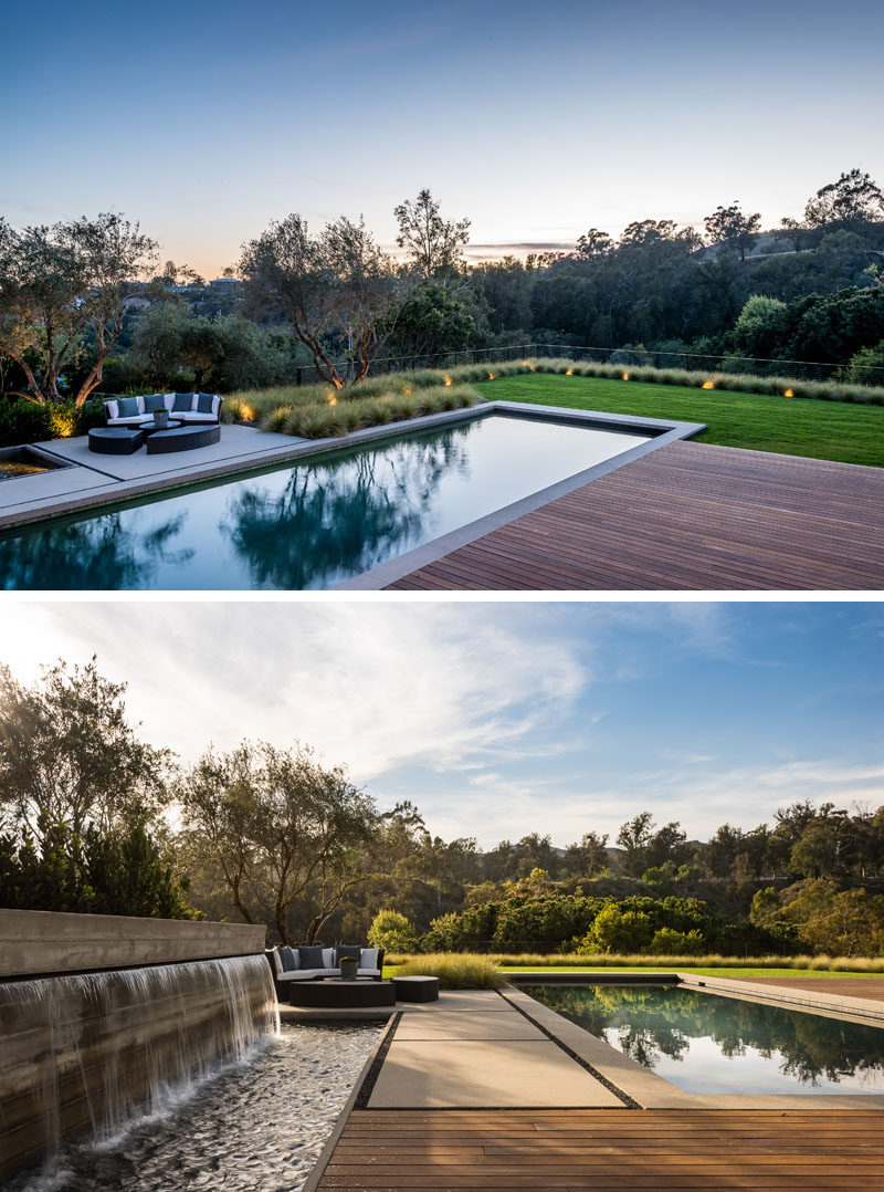 This modern backyard has a water feature, a 50-foot pool with a spa, and a wooden deck. #ModernBackyard #SwimmingPool #WaterFeature #Landscaping