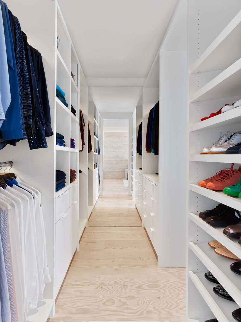 This modern walk-in closet as wide-plank Douglas Fir flooring and plenty of floor-to-ceiling shelving space. #WalkInCloset #InteriorDesign #Closet