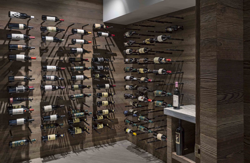 This modern wine cellar has wood lined walls and storage space for displaying the wine collection. #WineCellar #WineStorage