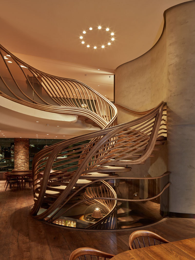 Atmos Studio have designed a sculptural wood spiral staircase that's the centerpiece for the 3-storey HIDE restaurant in London. Click through to see more photos of the staircase. #SpiralStairs #SculpturalStairs #Architecture #Design #WoodStairs