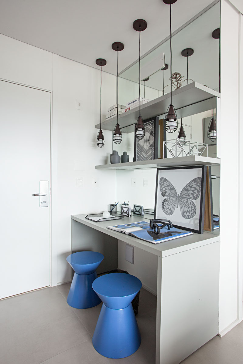 Stepping inside this small apartment, there's a desk area with a mirrored wall, that helps to make the entryway appear larger. #SmallApartment #HomeOffice #MirroredWall