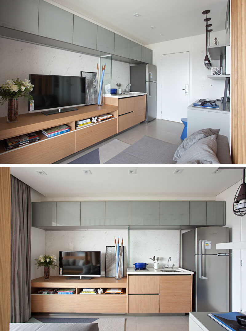 In this small apartment, a grey section of cabinets runs along the ceiling, creating much needed storage space in the small apartment, while a small glass divider separates the kitchen counter and the entertainment unit. #SmallApartment #SmallKitchen #InteriorDesign #Cabinets